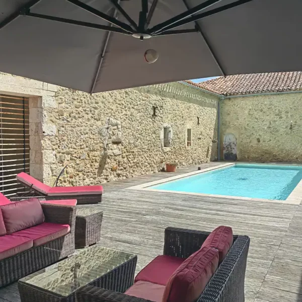 le patio et sa piscine de jour avec son salon de jardin au domaine de pourrouquet