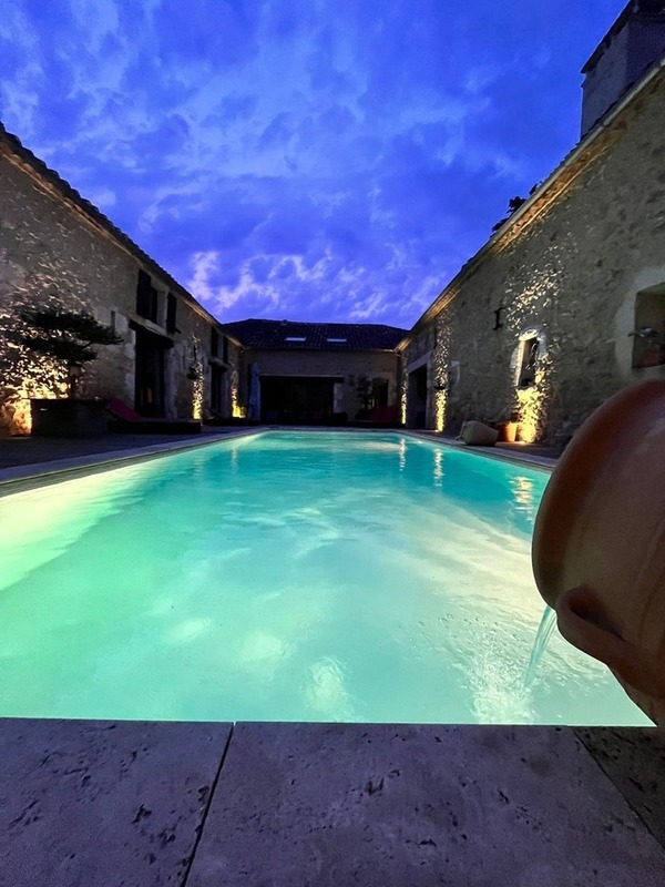 Vue du patio et piscine de nuit du domaine de pourouquet pour profiter de chambres d’hôtes et gîtes dans le gers